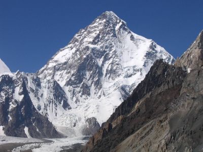 A large angular white mountain, with steeply sloped sides mostly covered with snow.